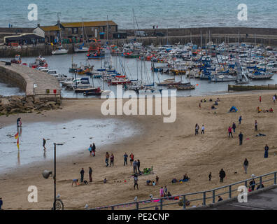 Lyme Regis, Dorset, UK. 12th August 2018. UK Weather: A wet and windy day in Lyme Regis. The popular beach at the seaside resort of Lyme Regis was much quieter than usual on Sunday afternoon.  Holidaymakers make the best of a break between the frequent heavy downpours. Credit: PQ/Alamy Live News. Stock Photo