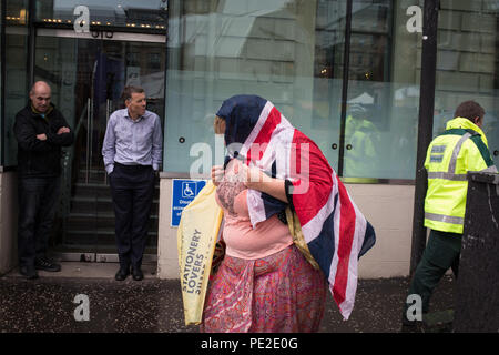 Woman with Union Jack flag shawl, in Glasgow, Scotland, on 8 August 2018. Stock Photo