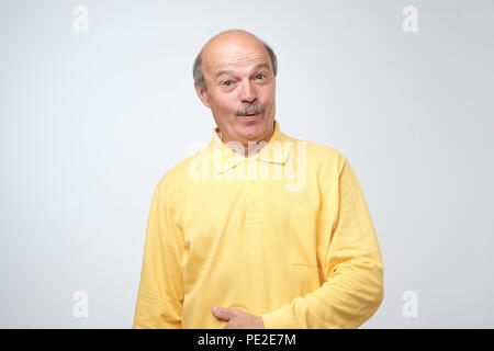 Wow concept. Attractive male half-length front portrait. Senior emotional surprised man standing with opened a little mouth. Human emotions, facial ex Stock Photo