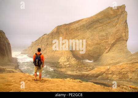 Hiker in Fog on the Cliffs of Cape Kiwanda in Pacific City Oregon Stock Photo