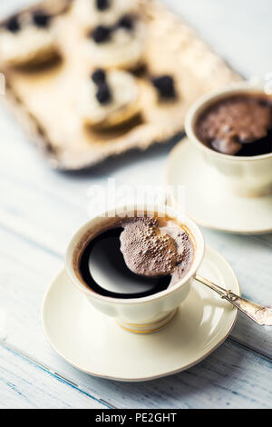 Cup of coffee with tasty cakes on table. Stock Photo
