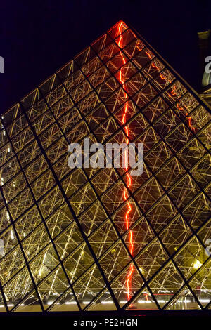 The entrance pyramid of the Louvre Museum at night in Paris, France Stock Photo