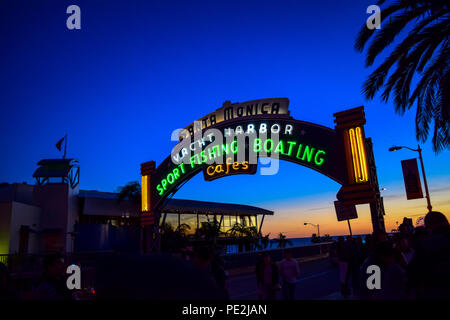 The Santa Monica Pier sign lit up at sunset in Santa Monica, California Stock Photo