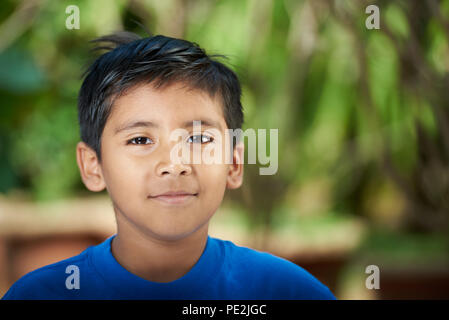 Portrait of latino boy on blurred sunny background Stock Photo