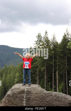 Little girl standing on a large rock in Gifford Pinchot National Forest, Washington Stock Photo