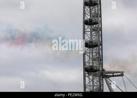 Coloured smoke lingering in the air after a Red Arrows flypast over the London Eye Stock Photo