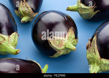round eggplant closeup on blue backgroun Stock Photo