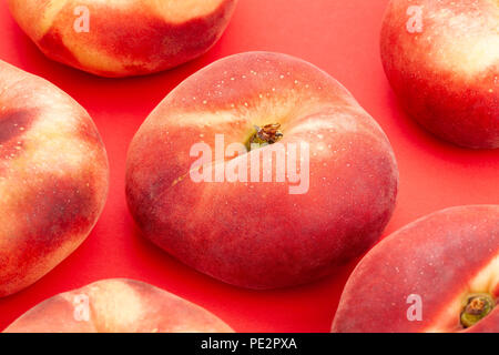 saturn peach closeup on red background Stock Photo