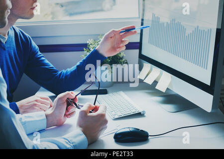 group of young business people coworkers looking together at computer, team working on new startup project in modern office, brainstorming concept Stock Photo