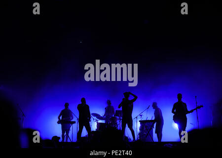 music band playing on concert stage, silhouettes of musicians unrecognizable, group of people singing together in rock festival Stock Photo