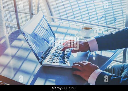 businessman working on computer in airport, banking online on internet, writing email, hands typing on keyboard Stock Photo