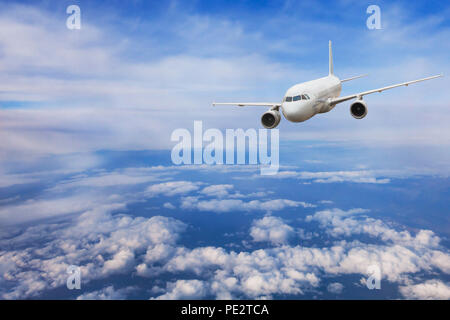 airplane flying above the clouds, travel concept, aircraft jet plane in blue sky Stock Photo