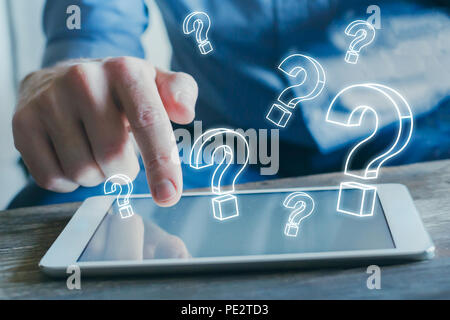 many quiestion marks from the screen of tablet computer, find answer online, FAQ concept, what where when how and why, search information on internet Stock Photo