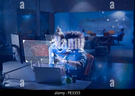 Two young designers are working on a new project in the night office using modern technology Stock Photo