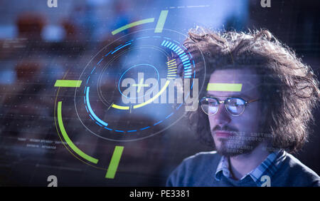 Young man working on computer at night in dark office. The designer works in the later time. Stock Photo