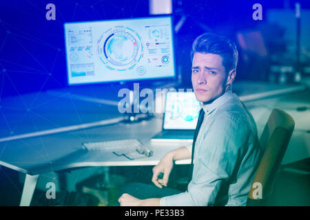 Young man working on computer at night in dark office. The designer works in the later time. Stock Photo