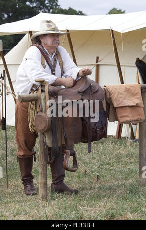 cowboy and his saddle leaning on a hitching post in the wild west. Stock Photo