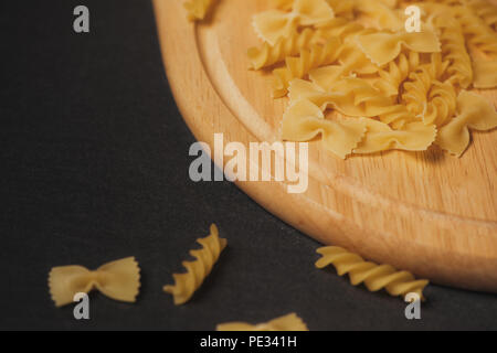 Variety of types and shapes of dry Italian pasta on dark background Stock Photo