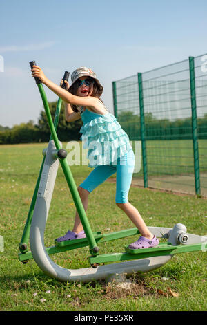 Young girl exercising in a public park Stock Photo