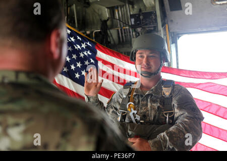 U.S. Army Spc. John McKenney repeats the oath of enlistment during his reenlistment ceremony on board the aircraft prior to the Sept. 11 memorial jump, Dobbins Air Reserve Base, Marietta, Ga., Sept. 11, 2015. Paratroopers from the Army Reserve and the Georgia Army National Guard came together to commemorate the anniversary of Sept. 11, 2001 as well as remember the sacrifices of fellow service members. (U.S. Army photo by Spc. Josephine Carlson/Released). Stock Photo