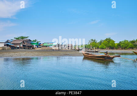 CHAUNG THA, MYANMAR - FEBRUARY 28, 2018: The poor fishing village with old shanties and boats at the Kangy river bank, on February 28 in Chaung Tha. Stock Photo