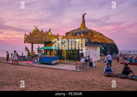 CHAUNG THA, MYANMAR - FEBRUARY 28, 2018: The scenic sunset view of Kyauk Pa Hto Pagoda with carved patterns, pillars and Naga-Raja, sculptures, on Feb Stock Photo