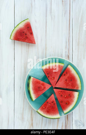 Watermelon slices on a blue plate. White wooden background, top view, high resolution Stock Photo