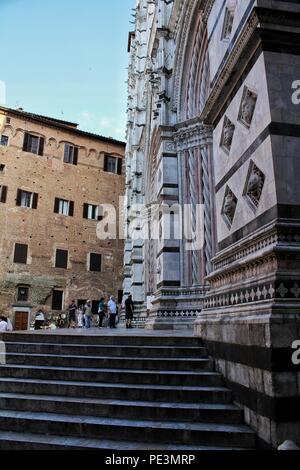 The stairs and part of the facade with architectural and decorative elements of the Siena Cathedral, Siena, Italy Stock Photo