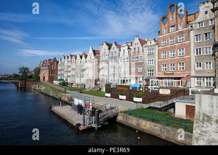 Row of traditional riverside houses with gables in Old Town of Gdansk city, Poland, ferry tram stop platform on Motlawa river Stock Photo