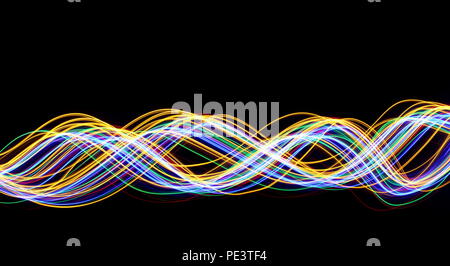 Multi color light painting photography, gold, red, green and blue waves of vibrant color against a black background Stock Photo