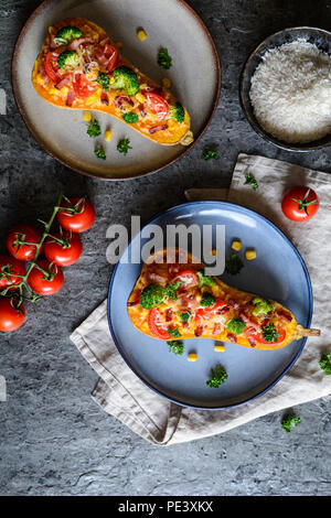 Roasted Butternut Squash stuffed with rice, bacon, broccoli, tomato, corn and cheese Stock Photo