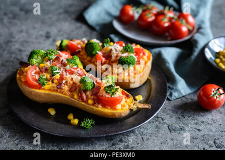 Roasted Butternut Squash stuffed with rice, bacon, broccoli, tomato, corn and cheese Stock Photo