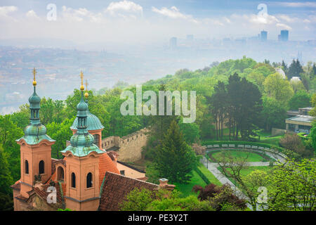 Petrin Hill Prague, aerial view of the St Lawrence Church on Petrin Hill seen against the backdrop of the mist shrouded Nove Mesto district, Prague. Stock Photo