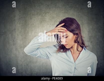 Closeup portrait of a sad young beautiful woman with worried stressed face expression looking down Stock Photo