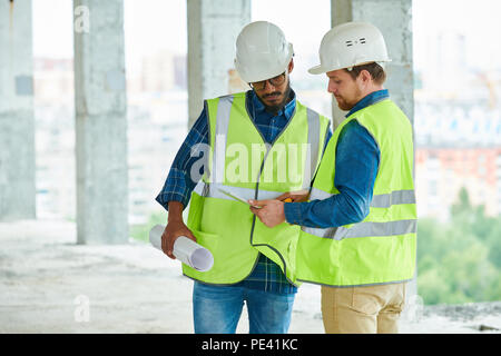 Construction engineers studying project on tablet Stock Photo