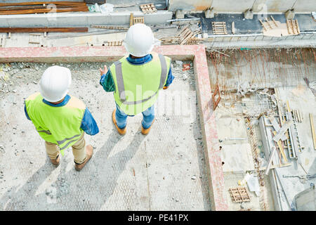 Anonymous construction engineers looking down Stock Photo