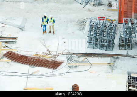 Engineers on reading blueprint on construction site Stock Photo