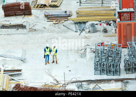 Building inspectors reading blueprint on construction site Stock Photo