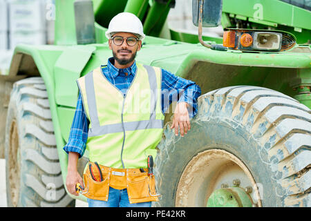 Relaxed engineer near heavy machine Stock Photo