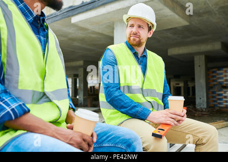 Construction engineer listening to colleague Stock Photo