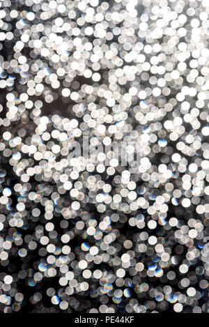 White flecks of defocused light creates a snowfall like bokeh effect in bright white colour for festive christmas concepts and ideas Stock Photo
