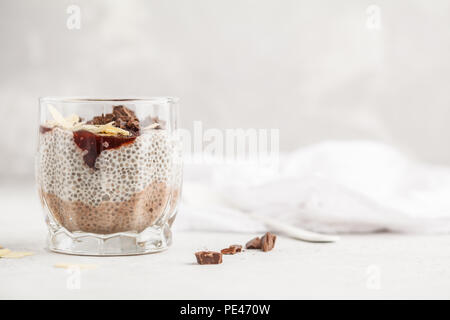 Chia pudding with chocolate, almonds and berry jam, white background. Raw vegan dessert. Clean eating concept. Stock Photo