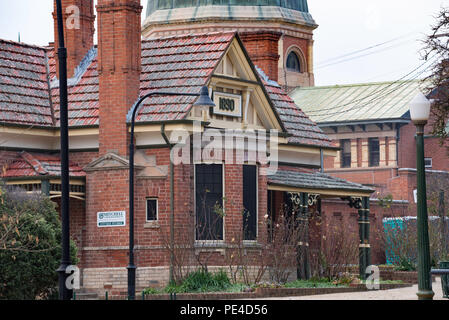 The Curators Cottage in Machattie Park Bathurst NSW is a Federation Queen Anne cottage of polychrome brick under a terra cotta tiled gabled roof. Stock Photo