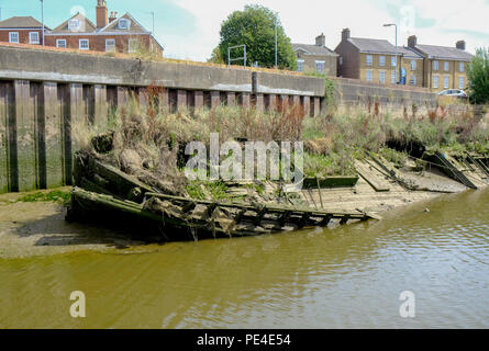 sunken brown wooden river boat in bright blue river full