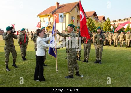 Turkey’s ambassador to Kosovo, Kivilcim Kilic, presents an honorary flag for the Turkish National Command Contingent to Kosovo to Col. Omer Faruk Demircioglu during his change of command ceremony Sept. 3, 2015, in Prizren, Kosovo. During the ceremony, Turkish Col. Saim Bagci assumed the command’s top post. JRD-S and its liaison monitoring teams are part of NATO’s peace support mission in the region, known as Kosovo Force.. (U.S. Army photo by Sgt. Erick Yates, Multinational Battle Group-East) Stock Photo