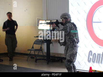 Spc. Julie Neff, a computer detection systems repairer with the 12th Combat Aviation Brigade, engages targets on a computer screen during the “gunfighter gym” event of the 2015 European Best Warrior Competition at Camp Aachen Sept. 13. Some 22 candidates are participating in the intense, grueling annual weeklong competition, the most prestigious competitive event of the region. Event organizers will announce the year’s top junior officer, noncommissioned officer and Soldier during a concluding ceremony slated for Friday, Sept. 18. (U.S. Army Photo by Staff Sgt. Warren W. Wright Jr., 21st TSC P Stock Photo