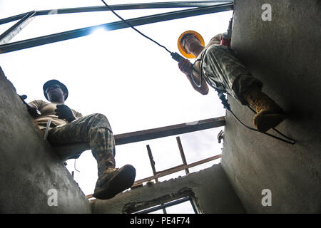 U.S. Louisiana National Guard Soldiers from 1022nd Engineer Company sit on top of a roof they are constructing during a school build apart of Operation Keris Strike, Pacific Pathways 2015 at Tai Ping, Malaysia, on Sept. 9, 2015. Operation Keris Strike is a regularly scheduled bilateral exercise sponsored by U.S. Army-Pacific, hosted annually by the Tentera Darat Malaysia to promote regional security, support and cooperation. (U.S. Army Photo by Spc. Michael Sharp/Released) Stock Photo