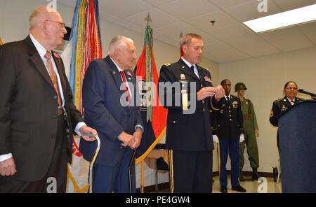 Brig. Gen. Steven Ainsworth, commander 94th Training Division, explains the significance of his commander’s coin before presenting it to WWII veteran Vincenzo Geramita during a ceremony where Ainsworth awarded Bronze Star medals to Geramita and Andrew Cella at Fort Dix, N.J., Sept. 12, 2015. Ainsworth, who also presented a coin to Cella, noted that this was the first time he’d been afforded the opportunity to present the coin to WWII veterans. Stock Photo