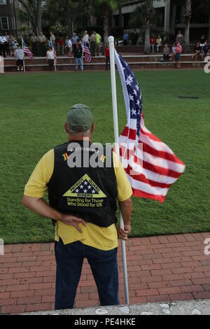A Vietnam veteran holds the American Flag while at parade rest during a 9/11 memorial ceremony Sept. 11. The veteran, along with several other veterans, held American flags during the ceremony to honor the men, women, and heroes who lost their lives in the tragic events that happened on Sept. 11, 2001. The veterans are with the Patriot Guard Riders, a motorcycle group comprised of retired service members. Stock Photo
