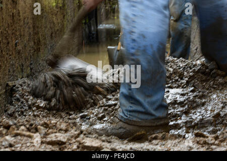 Mud is scraped into a pile to clear an irrigation drain at Kanuma City, Tochigi prefecture, Sept. 15, 2015. More the 60 volunteers from Yokota Air Base spent three days assisting the local community in post-flood and landslide. The local elementary school allowed many of the volunteers to sleep in the gym in gratitude of the volunteer's service. (U.S. Air Force photo by Staff Sgt. Cody H. Ramirez/Released) Stock Photo